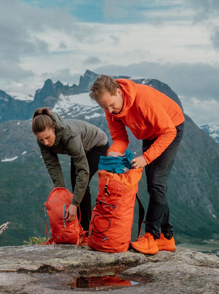 Viser bilde av to personer på tur i fjellet som pakker hver sin sekk.